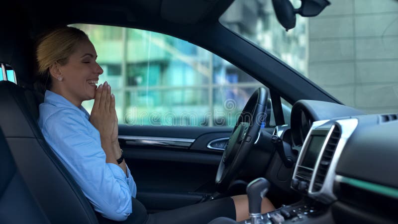 Smiling woman sitting in new car, satisfied with luxury service during purchase, stock photo. Smiling woman sitting in new car, satisfied with luxury service during purchase, stock photo